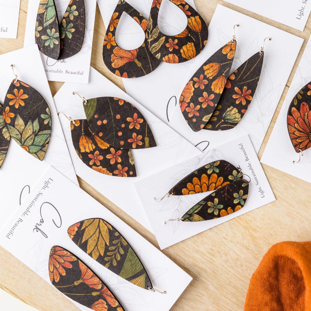 Pair of autumn-themed leaf-shaped earrings on a white card with 'Cork' branding.
