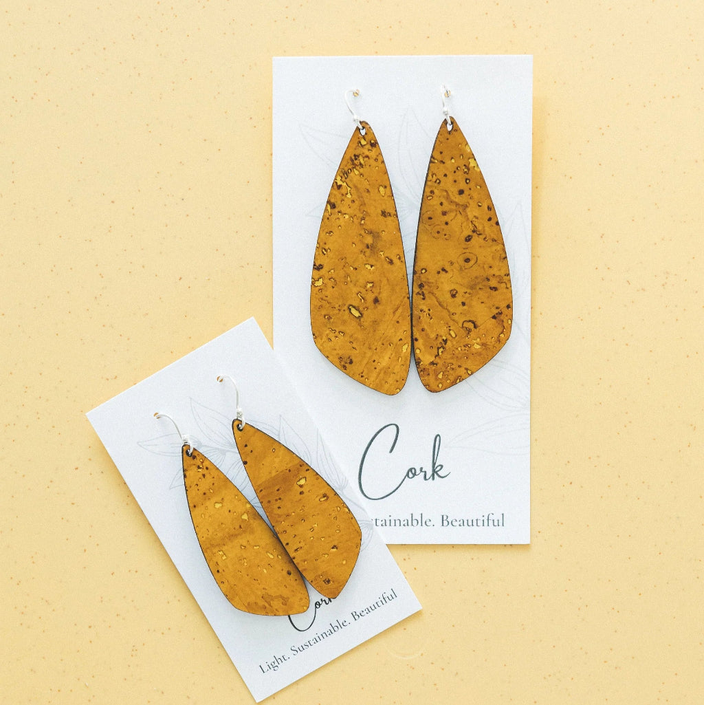 Pair of cork earrings on a white card with 'Cork' text against a beige background